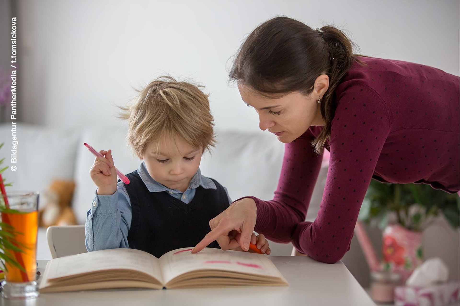 Lernen: Frau zeigt Kind in einem Buch etwas