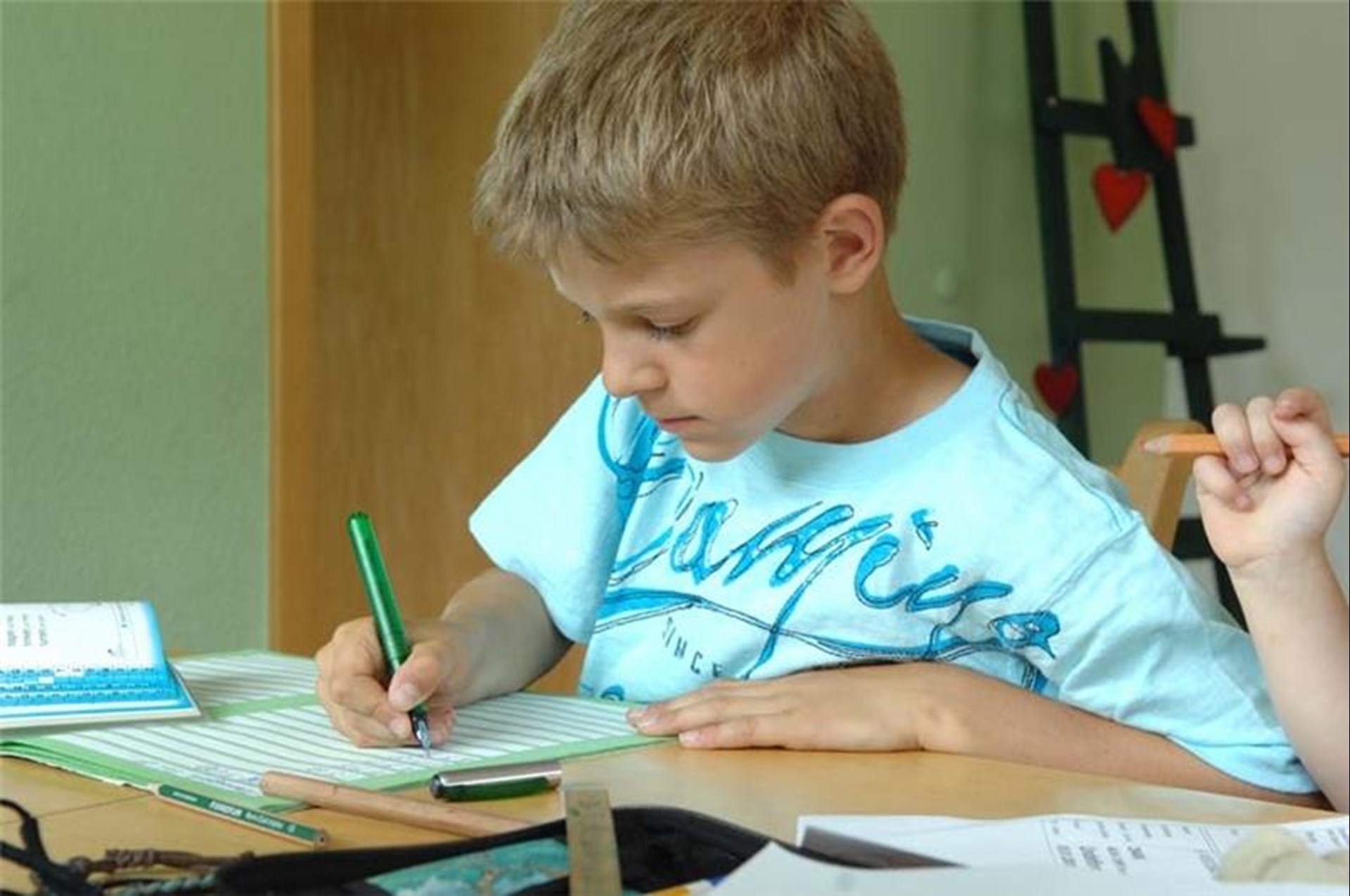 Kind schreibt in ein Heft